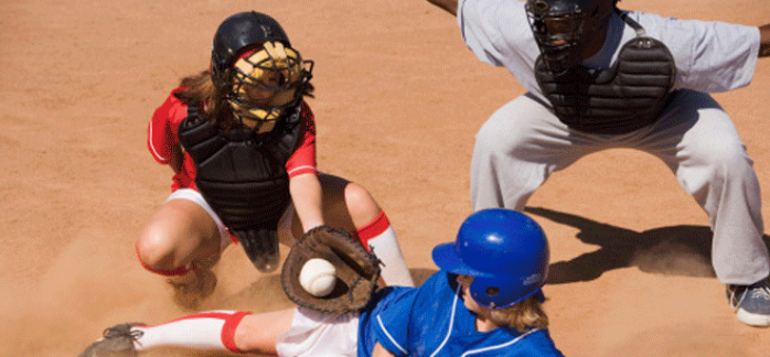 Girls making a play at home base while an umpire looks on